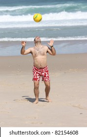 A Fat Man Playing With A Ball On The Beach