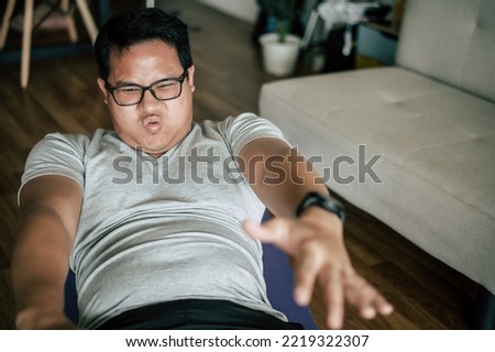 Fat man practicing doing crunches or sit ups on yaga mat, fitness program for weight loss, healthy lifestyle concept, copy space
