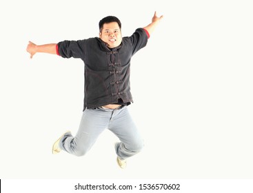 Fat man is pretending to jump from a high place and smile happily isolated on white background  - Shutterstock ID 1536570602