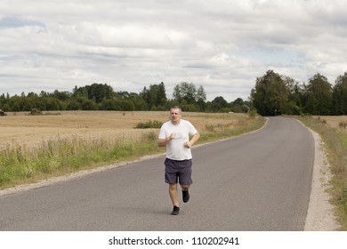 Fat man running on a rural road