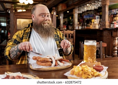 Fat man tasting frankfurters in pub