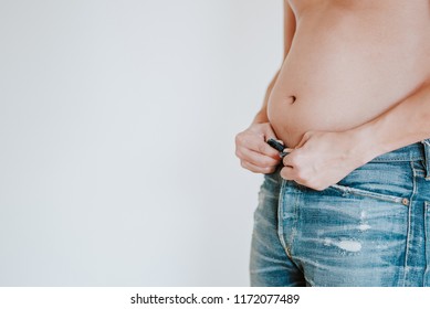 Fat Man Trying So Hard To Put Down His Jeans Pant Button, Stuck Because His Big Fat Belly, Check Out His Body Fat Suffering From Extra Weight, Fitness And Diet Concept Isolated On White Background