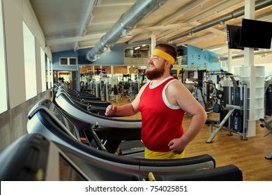 A fat man is walking running along a treadmill in the gym.
