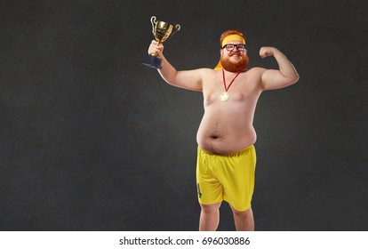 Fat Naked Man With A Champion's Cup In His Hands. 