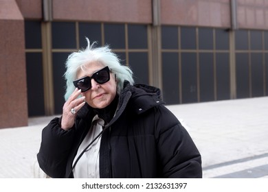 Fat Older Woman In Coat And Big Black Sunglasses Looking At Camera Outdoors