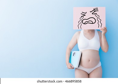Fat overweight woman take crying billboard and Body weight with blue background, asian