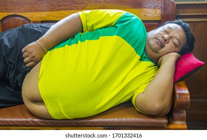 Fat Person Sleep On Wood Sofa,fat Man Laying On The Wood Couch.