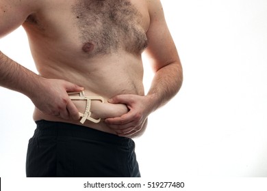 Fat pinch test and weight control concept - Overweight man is pinching himself with calipers to measure the fat level
