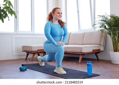 Fat Redhead Woman Doing Lunges On Mat, Engaged In Fitness, At Home, Wearing Blue Sportive Outfit, Stretching Body, Warming Up Muscles, Lead Healthy Lifestyle. Oversize Plus Size Model Workout