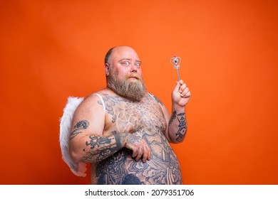 Fat Thoughtful Man With Beard ,tattoos And Wings Acts Like An Magic Fairy