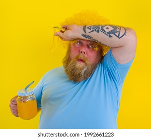 Fat Tired Man With Wig In Head And Sunglasses Drinks A Fruit Juice