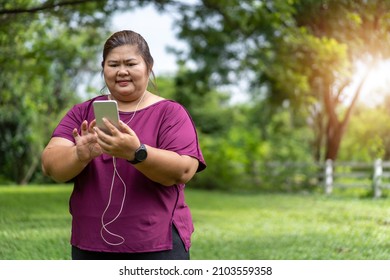 Fat Woman Asian Holding Smart Phone With Listening To Music. Exercise Outdoors For Weight Loss Idea Concept