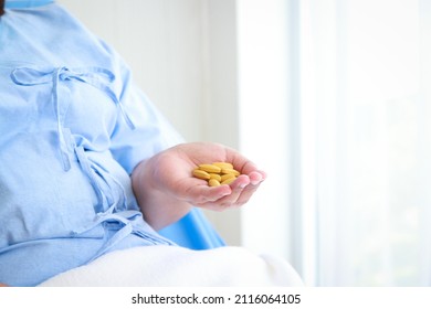 fat woman being treated in hospital She was lying on the bed holding a yellow medicine pill. Concept of medical services in hospitals. health insurance. copy space