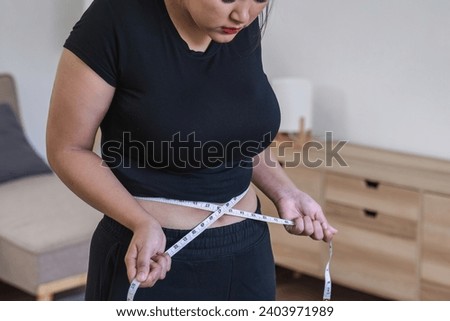 Fat woman, fat belly, obesity, fat woman's hand holding excessive belly fat with measuring tape, female lifestyle concept