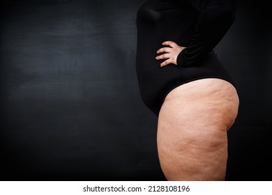 a fat woman with cellulite stands sideways on a black background. High quality photo - Shutterstock ID 2128108196