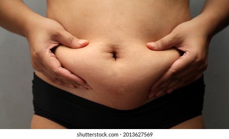 Fat Woman Checking And Pinching Excess Fat On Her Hips.