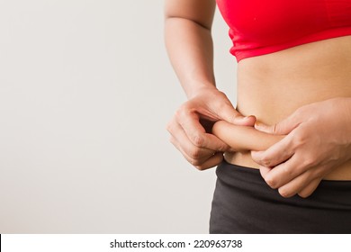 fat woman, fat girl, fat belly; chubby, obese woman hand holding excessive belly fat; overweight fatty belly of woman; woman diet lifestyle concept to reduce belly and shape up healthy stomach muscle