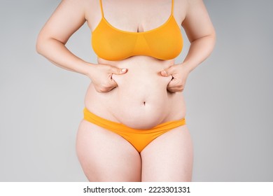 Fat woman in orange underwear on gray background, overweight female body, body positive concept - Shutterstock ID 2223301331