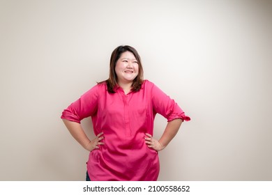 Fat woman pink shirt, Obese woman hand holding excessive belly fat isolated on clean background, Overweight fatty belly of woman diet lifestyle overweight Happy and self-esteem concept.