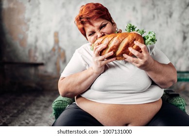 Fat woman sits in chair and eats sandwich, bulimic