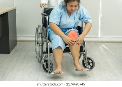 Fat Woman Sitting On Wheelchair Holding On Her Knee Pain.