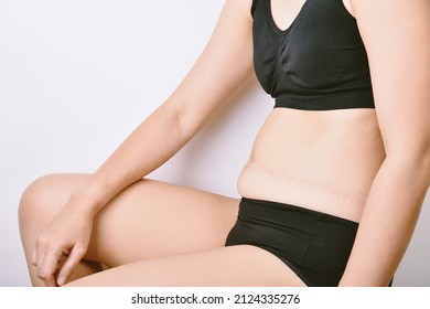 Fat woman sitting and showing belly fat, Overweight obesity woman, Woman muffin top waistline.