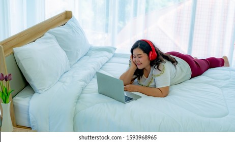 Fat Woman Using Headphone Listening Music From Laptop In The Bedroom Happily