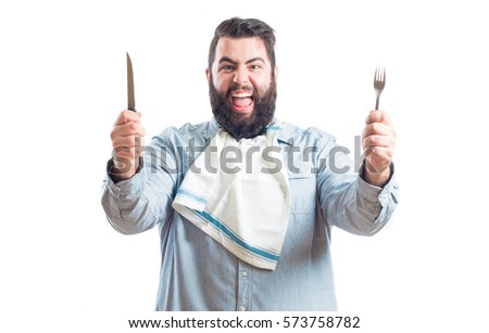 
Fat young man with a napkin in the neck of his shirt holding a knife and a fork isolated on white background