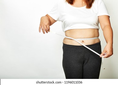 Fat young woman asian with measure tape studio on white background. - Shutterstock ID 1196011036