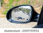 Fatal accident of a Pedestrian run over and lying dead on the road seen through the rearview mirror. Car insurance. Hit and run concept.