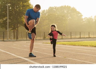 Fathe and daughter go in sports.Child at the stadium.Jogging family.Man and girl.Family spending time together.Child education.