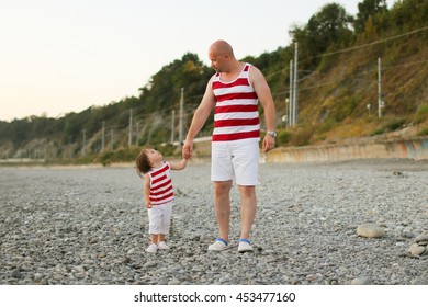 Father And 2 Years Son In Similar Clothes Look At Together