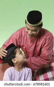 Father Adjusting Songkok For His Son 