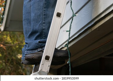 Father And Adult Son Hanging Christmas Lights