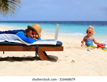 Father Asleep On Laptop While Child Play At Beach, Family Vacation