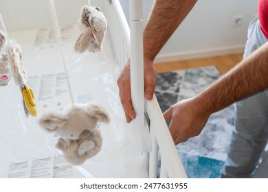  Father Assembling Baby Crib with Animal Mobile - Powered by Shutterstock