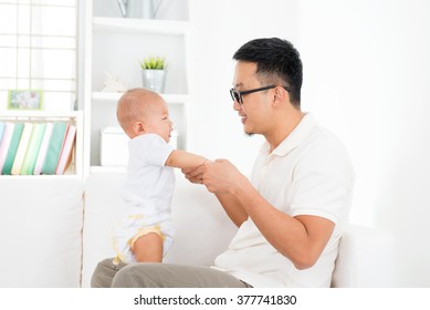 Father And Baby Boy Playing At Home. Southeast Asian Family Lifestyle Indoors.