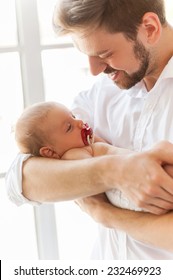 Father And Baby. Close-up Of Father Holding Cute Little Baby In Hands And Smiling