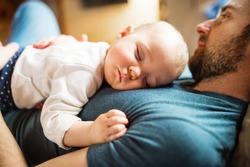 Father With A Baby Girl At Home Sleeping.