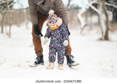 Father And Baby Girl Playing In The Snow During Wintertime