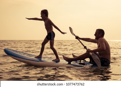 Father and baby son playing on the beach at the day time. People having fun outdoors. Concept of summer vacation and friendly family. - Powered by Shutterstock