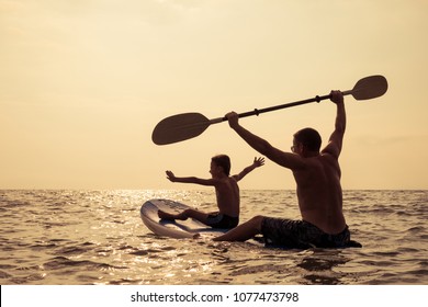 Father and baby son playing on the beach at the day time. People having fun outdoors. Concept of summer vacation and friendly family. - Powered by Shutterstock