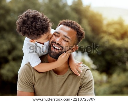 Father, bonding kiss and boy child hug happy in nature with quality time together outdoor. Happiness, laughing and family love of a dad and kid in a park enjoying nature hugging with care and a smile