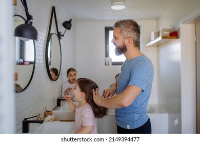 Father brushing his little daughter's hair in bathroom, morning routine concept. - Powered by Shutterstock