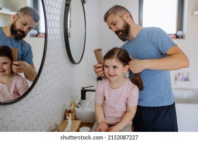 Father brushing his little daughter's hair in bathroom, morning routine concept. - Powered by Shutterstock