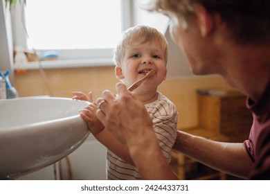 Father brushing little baby boy's teeth in the morning. Morning dental hygiene for toddlers. - Powered by Shutterstock