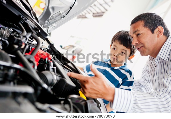 Father buying car with his son and explaining\
to him about mechanics