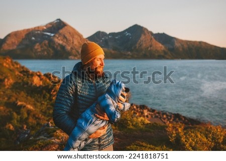 Father carrying baby outdoor family travel in Norway active vacations hiking healthy lifestyle man parent walking with infant child autumn season