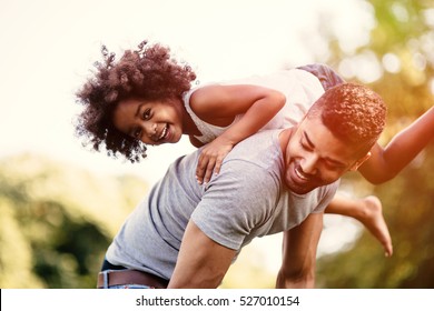 Father carrying daughter on back outdoors