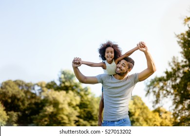 Father carrying daughter on back outdoors